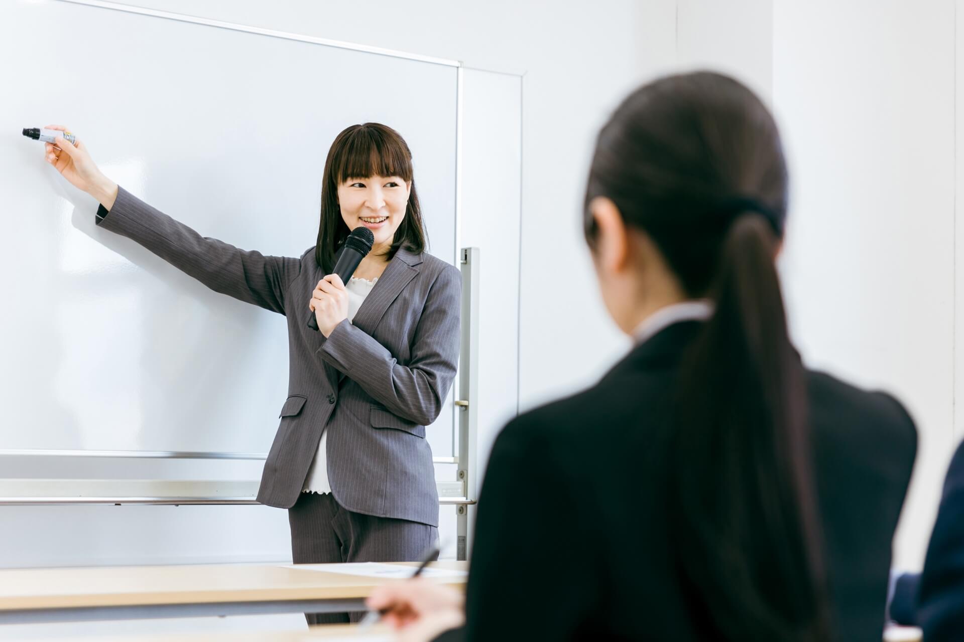 ホワイトボードで発表するビジネス女性