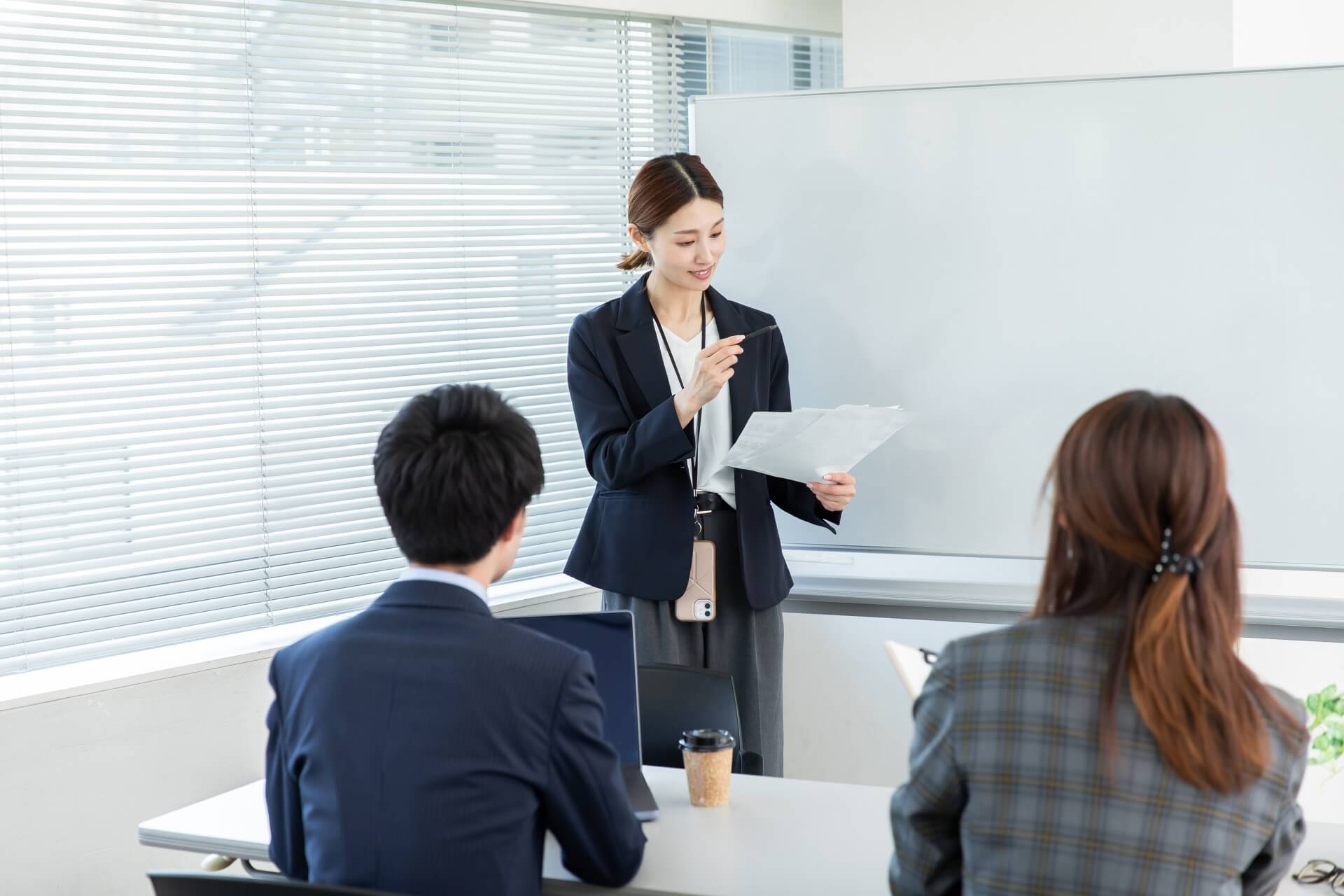 ホワイトボード前で発表する女性
